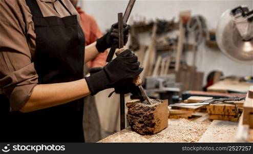 female carpenter sculpting wood studio