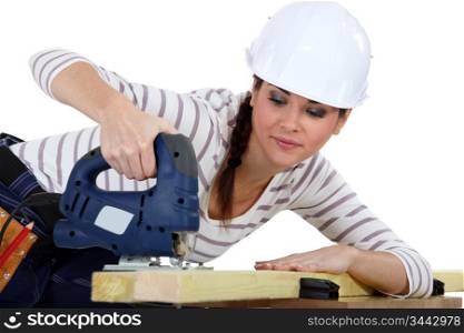 Female carpenter using a jigsaw.