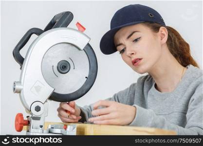 female carpenter using circular saw for wood