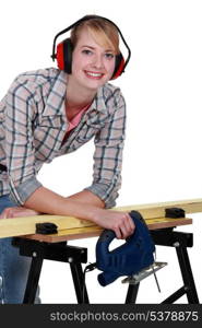 Female carpenter wearing protective muffs