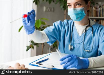 Female caucasian doctor holding a swab collection stick, nasal and oral specimen swabbing in doctor?s office, patient PCR testing procedure appointment, Coronavirus COVID-19 global pandemic crisis