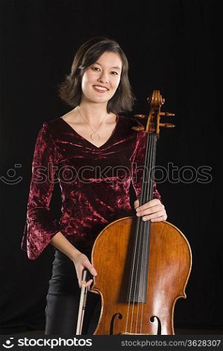 Female cellist stands with cello portrait