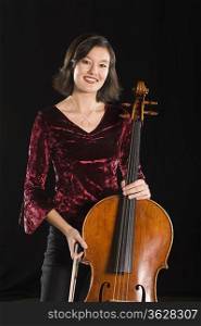 Female cellist stands with cello portrait