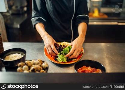 Female chef cooking meat salad on wooden table. Garnish for beefsteak, food preparation on kitchen. Female chef cooking meat salad on wooden table
