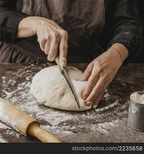 female chef cutting pizza dough half