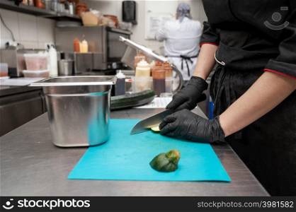 Female chef cutting vegetables at a commercial kitchen. High quality photo. Female chef cutting vegetables at a commercial kitchen.