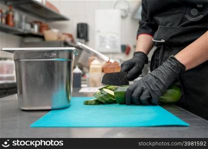 Female chef cutting vegetables at a commercial kitchen. High quality photo. Female chef cutting vegetables at a commercial kitchen.