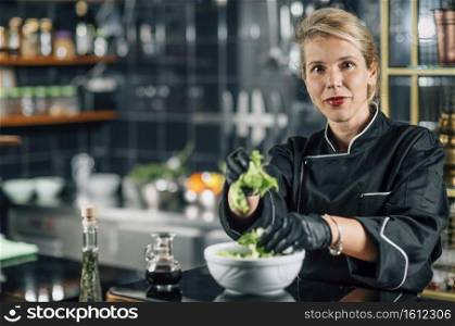 Female chef making healthy vegan salad. Female Chef Making Vegan Salad