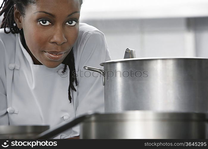 Female chef near saucepan in kitchen, portrait