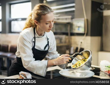 female chef pouring food plate