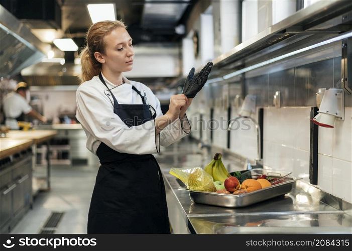 female chef putting glove kitchen