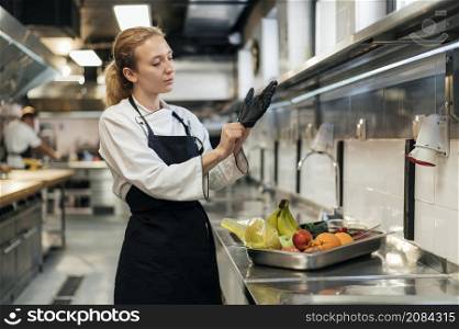 female chef putting glove kitchen