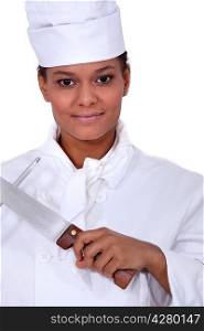 Female chef sharpening a knife
