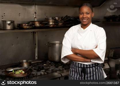 Female Chef Standing Next To Cooker In Restaurant Kitchen
