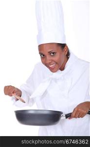 Female chef stirring sauce