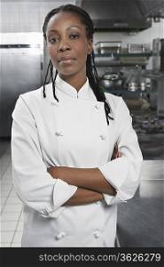 Female chef with arms crossed in kitchen, portrait