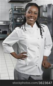 Female chef with hand on hip in kitchen, portrait