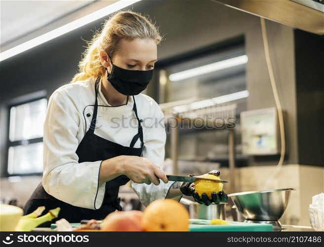 female chef with mask slicing fruit