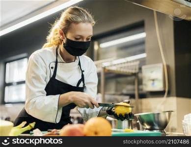 female chef with mask slicing fruit