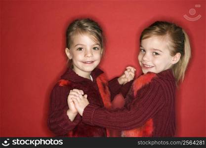 Female children Caucasian twins standing in dance stance.