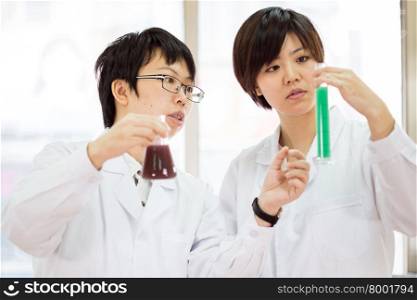 Female Chinese scientists in a laboratory inspecting chemicals