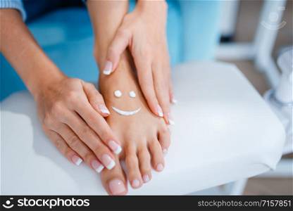 Female client shows perfectly made nails in beauty shop. Professional manicure and pedicure service, hands and legs treatment, client in beautician salon, woman at the cosmetologist