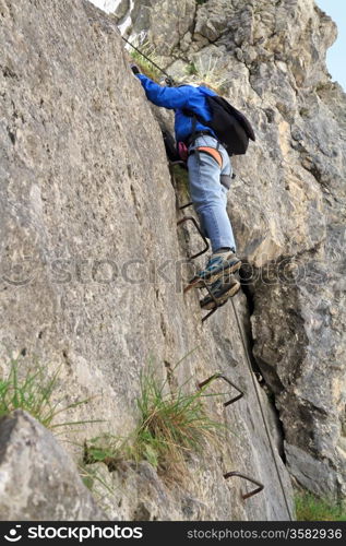 female climber with white helmet on Sass de Rocia via ferrata, italian Dolomites