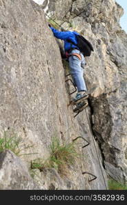 female climber with white helmet on Sass de Rocia via ferrata, italian Dolomites