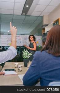 Female coach looking at woman with index finger up to make question in a business meeting. Female coach looking woman to make question in business meeting