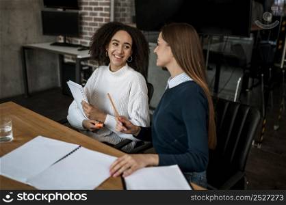 female colleagues talking each other during meeting