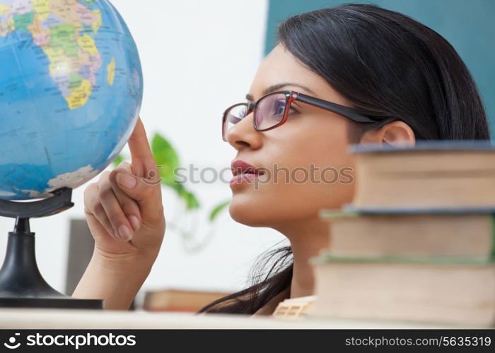 Female college student looking at a globe