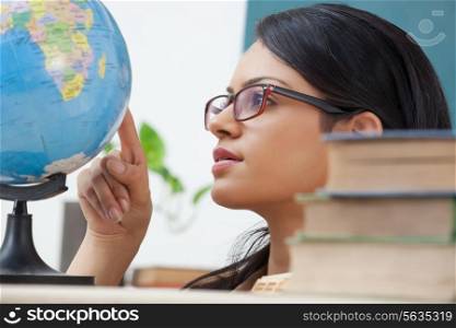 Female college student looking at a globe
