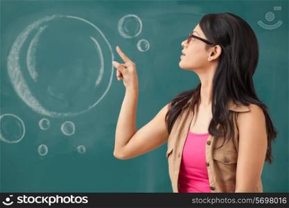 Female college student pointing at blackboard