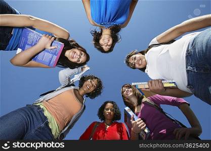 Female college students standing in circle, view from below