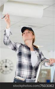 female construction worker assembling a suspended ceiling