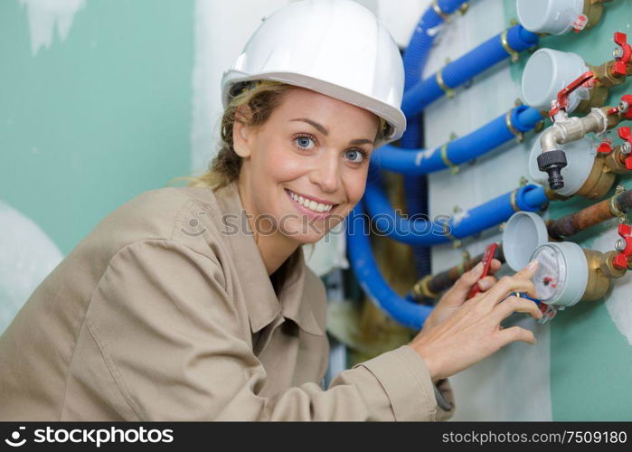 female construction worker checking water meter