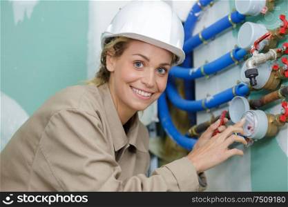 female construction worker checking water meter