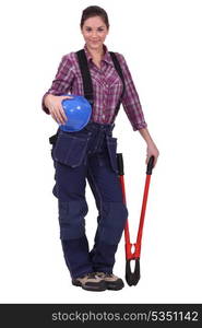 Female construction worker holding a large tool