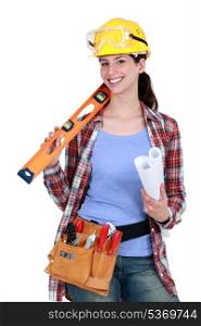 Female construction worker holding tools and a rolled-up plan
