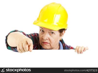 Female construction worker leaning over blank space and pointing, with a warning look on her face. Isolated design element.