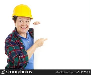 Female construction worker pointing at a blank sign. Isolated on white.