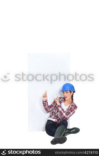 Female construction worker pointing at copyspace