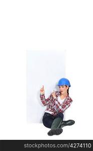 Female construction worker pointing at copyspace