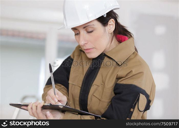 female construction worker taking notes at the construction site