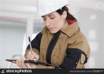 female construction worker taking notes at the construction site