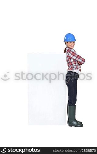 Female construction worker with a board left blank for your message