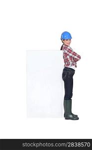 Female construction worker with a board left blank for your message