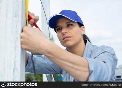 female construction worker with a tape measure