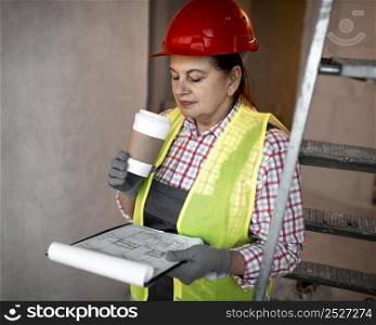 female construction worker with coffee plan