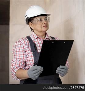 female construction worker with helmet clipboard
